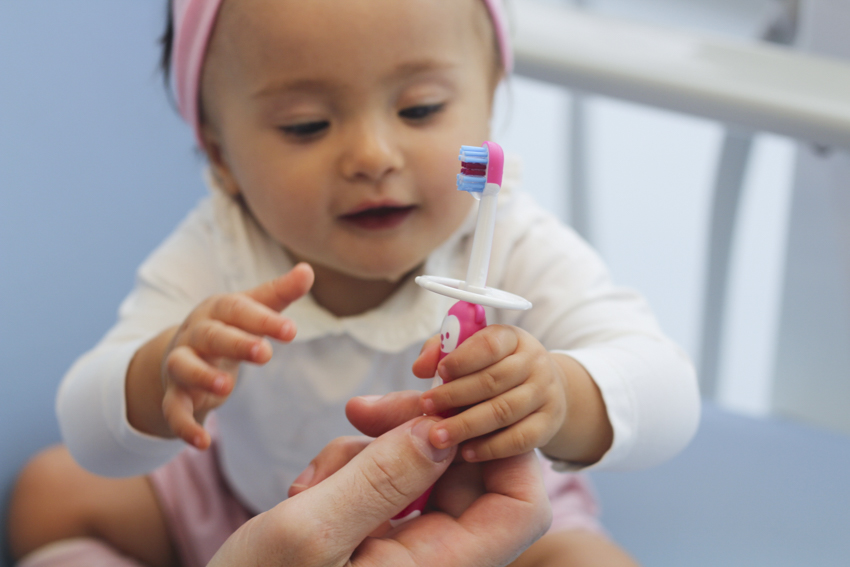 bambina con spazzolino dal dentista prima visita